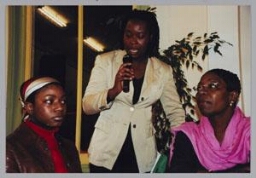 In het midden Monique Hoogmoed, stand-up comedian/actrice, tijdens een Zamicasa over rollenpatronen na migratie. 2000