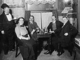 Johanna Westerdijk (zittend links) in gezelschap van vier mannen aan een tafeltje in café Eik en Linde te Amsterdam (de Eik en Lindeclub?) ca. 1912