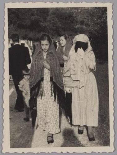 Vrouw met abaya en sluier die het gehele gezicht bedekt en een meisje met doek om hoofd lopen op een onverharde weg 193?