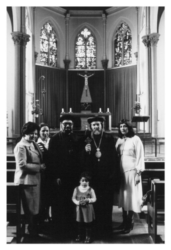 Priesters staan samen met een gezin in een kerk. 198?
