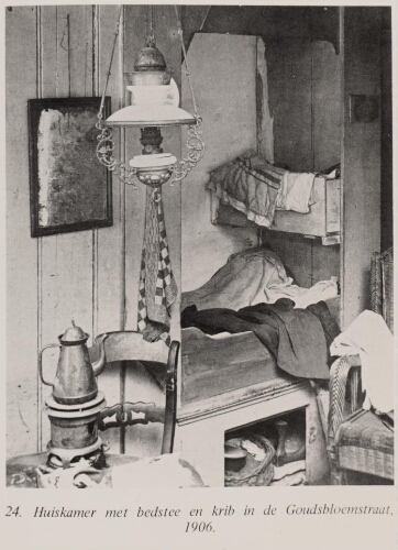 Bijschrift: 'Huiskamer met bedstee en krib in de Goudsbloemstraat'. 1906