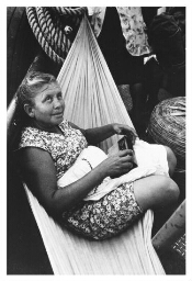 Tijdens een overtocht met een boot luistert een vrouw, zittend in een hangmat, naar de radio. 1984