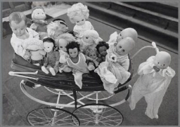 Een kinderwagen overvol met poppen 1990