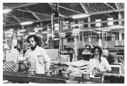 Joegoslavische man en vrouw achter de lopende band in zuurwarenfabriek Luijks. 1977