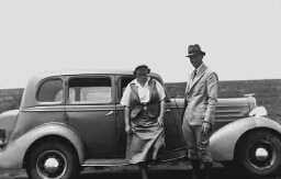 Man en vrouw poseren bij auto 1938