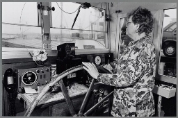 Vrouw van binnenvaartschipper aan het roer van een schip. 1993