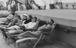 Johanna Westerdijk (derde van rechts) in gezelschap op ligstoelen op het dek van een schip 1938