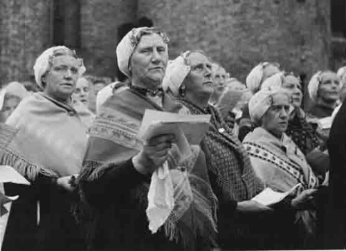 Zangkoor van Scheveningse vrouwen in klederdracht zingt tijdens het Vrouwendefilé op het Binnenhof, georganiseerd door de Tentoonstelling 'De Nederlandse Vrouw 1898-1948' in samenwerking met het Comité De Nationale Feestrok. 1948