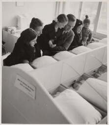 Duitse familie komt naar hun nieuwe familielid kijken op de kraamafdeling. 1937