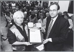 Tijdens 'Arachne borrel' op Prinsjesdag, overhandigt Willemien Ruygrok aan minister Melkert de publicatie 'Feiten en cijfers' 1997