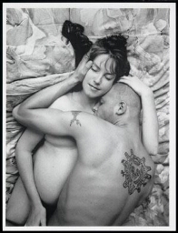 Naakte zwangere vrouw en naakte man liggen omarmd op bed 1996