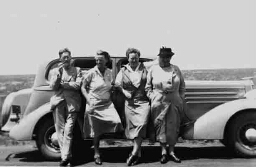 Johanna Westerdijk (rechts), Margaretha Mes (tweede van rechts) poserend voor een auto 1938