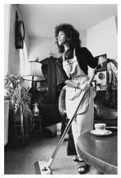 Fatima, medisch-receptioniste thuis aan het stofzuigen. 1990