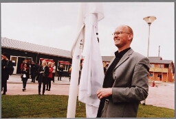 Tjeerd Herrema,stadsdeelvoorzitter Amsterdam Zeeburg, hijst de vlag tijdens de opening van het Asiel ZoekersCentrum (AZC) Zeeburg in Amsterdam 2001