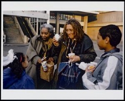 Portret van Gloria Wekker, haar partner en twee kinderen op straat met eten van de Burger King 200?