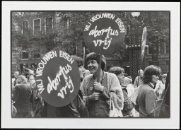 Groep vrouwen met twee ronde borden met tekst 'Wij vrouwen eisen - abortus vrij'. 1980