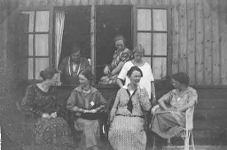 Groep vrouwen zittend voor gebouw 1900?