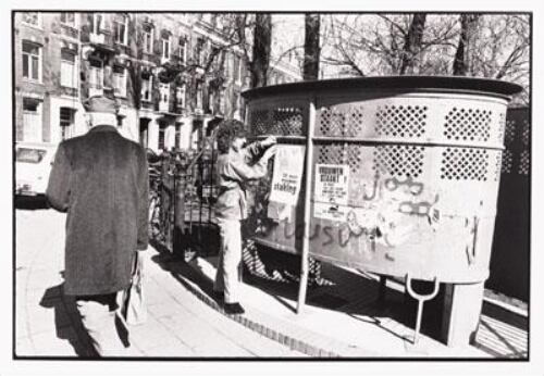 Vrouw plakt affiches met tekst: 'Vrouwen staakt ! 30 maart laat deze nieuwe abortuswet niet door de kamer komen' op een 'Amsterdamse krul' (een openbaar herentoilet of urinoir) bij het Sarphatipark in Amsterdam. 1981