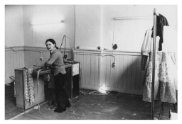 Vrouw in een Turks confectiebedrijfje aan het strijken. 1977