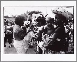 Vrouw met baby bij een carnavalsoptocht, Curaçao. 1986
