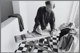 Illustraties bij het thema 'Wie zorgt er voor het huishouden als er geen huisvrouwen meer zijn ?' Man aan het strijken. 1989