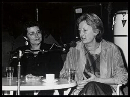 'Catharina Dracopoulou, Ombudsvrouw voor minderheden, en Annie Brouwer, wethoudster en loco-burgemeester Nijmegen, in forum ter gelegenheid van het 5-jarig bestaan van Vrouwenwerkwinkel Nijmegen.' (Zie ook: 100025124 t/m 100025129) 1986