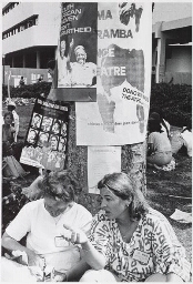 Op het universiteitsterrein zitten Zuid-Afrikaanse delegatieleden, op een boom een affiche: 'South African women fight apartheid'. 1985