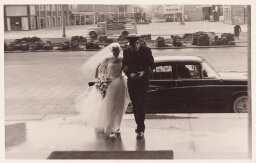Bruid en bruidegom stappen uit auto voor het stadhuis. 195?