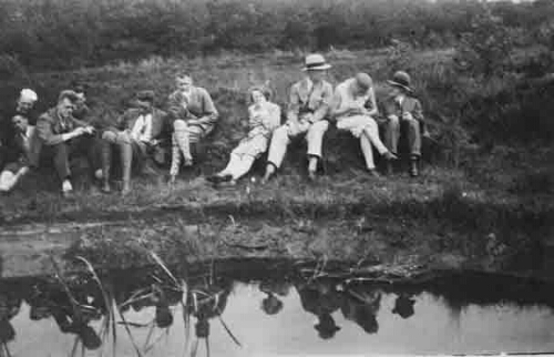 Zittend in gras aan water 1930