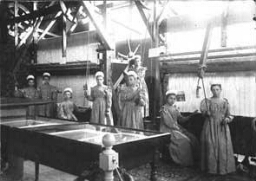 Groepsportret van meisjes in een weverij op de afdeling industrie van de Nationale Tentoonstelling van Vrouwenarbeid 1898. 1898