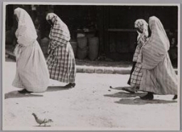 Vrouwen met abaya en sluier die het gehele gezicht bedekt lopen over straat in Sarajevo. 193?