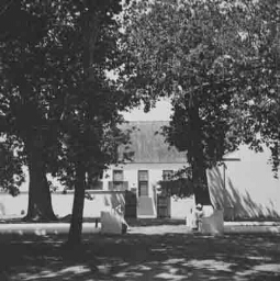 Een of twee personen zittend voor een huis 1938
