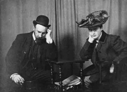 Geënsceneerde foto, deel uitmakend van een serie van twee: Johanna Westerdijk en een onbekende man zitten neerslachtig naar de grond te turen 1906