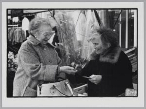 Een vrouw betaalt een marktvrouw op de Albert Cuypmarkt 1978