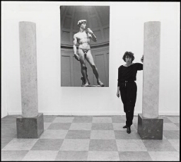 Portret van vrouw, leunend tegen een pilaar met een grote foto van het standbeeld van  'David' van Michelangelo. 1988