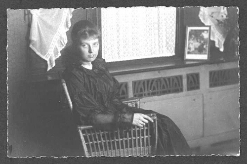 Portret van een jonge vrouw [Willie Scheer?] op een stoel bij het raam. 190?