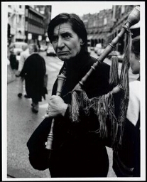 Portret van Arina Stam op hoek Elandstraat/Hazenstraat in Amsterdam met historisch blaasinstrument in haar arm 1984
