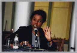 Domenica Ghidei Büdu, jurist en schrijfster van het boek 'Door het oog van de naald', over de praktijk van de asielprocedure, tijdens Café Zamicasa over beeldvorming en vreemdelingenbeleid. 1999