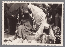 Vrouwen met abaya en sluier die het gehele gezicht bedekt op de markt in Sarajevo. 193?