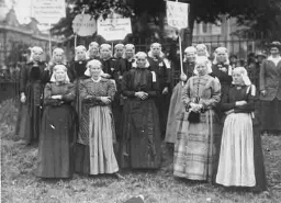 Vrouwen in klederdracht met vaandels van de Vereeniging voor Vrouwenkiesrecht 1916