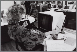 Vrouw doet beeldschermwerk achter computer. 198?